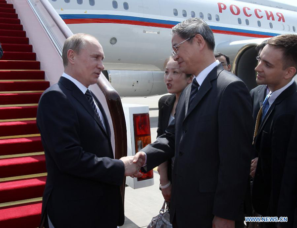 Russian President Vladimir Putin (L) is greeted by Chinese Vice Foreign Minister Zhang Zhijun upon his arrival in Beijing, capital of China, June 5, 2012. Putin arrived in Beijing on Tuesday, kicking off a three-day state visit to China. During the visit, Putin will attend the 12th Meeting of the Council of Heads of Member States of the Shanghai Cooperation Organization (SCO) in Beijing on June 6-7. [Pang Xinglei/Xinhua] 