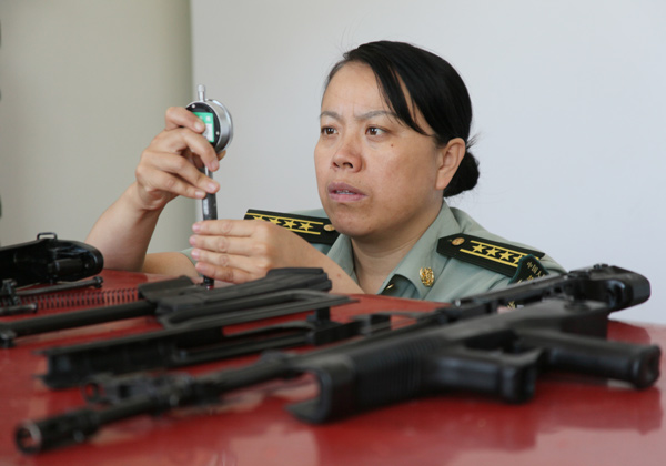 Huang Xueying, a 44-year-old who has 21 years of experience as a firearms tester, checks on a gun at a weapons test facility in Baicheng, Jilin province, in this file photo taken in June, 2010. [ Photo / China Daily ]