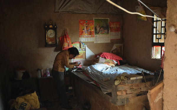 Li Hongfang, 40, suffers from chordoma, a type of bone cancer. She lives in Tianchao village in Qian county of Xianyang, Northwest China's Shaanxi province, May 30, 2012. [ Photo / China Daily ]