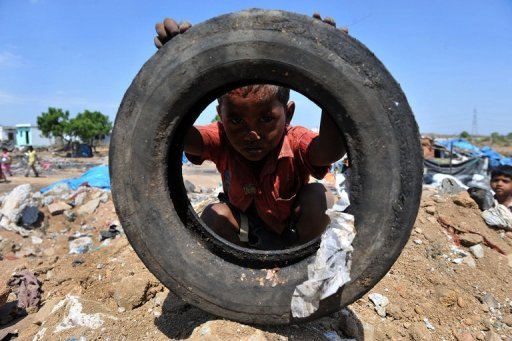 An Indian child plays with a tire in a slum on the outskirts of Hyderabad. [Agencies]