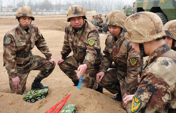 Colonel Wei Deming, a regimental commander under the Jinan Military Area Command of the People's Liberation Army, explains tactics to his officers during a drill in Henan province. [ Photo / China Daily ]