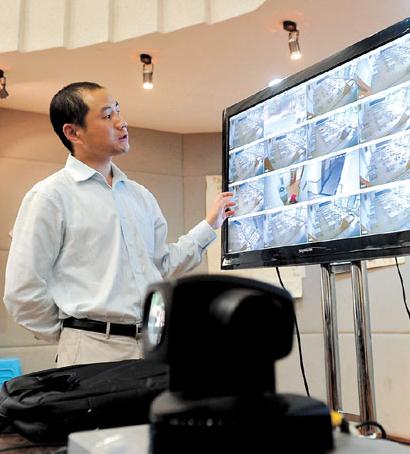 A faculty staff member tests the monitoring system at East China Model High School in Jing'an District yesterday to prepare for today's National College Entrance Exam, which will be attended by 9 million high school students across China. Strict measures have been taken to scuttle cheating on the big test.