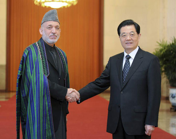 Chinese President Hu Jintao (R) shakes hands with his Afghan counterpart Hamid Karzai during a welcoming ceremony at the Great Hall of the People in Beijing, capital of China, June 8, 2012. Hamid Karzai was in Beijing for an official visit to China and attended the 12th Meeting of the Council of Heads of Member States of the Shanghai Cooperation Organization (SCO). [Xie Huanchi/Xinhua]