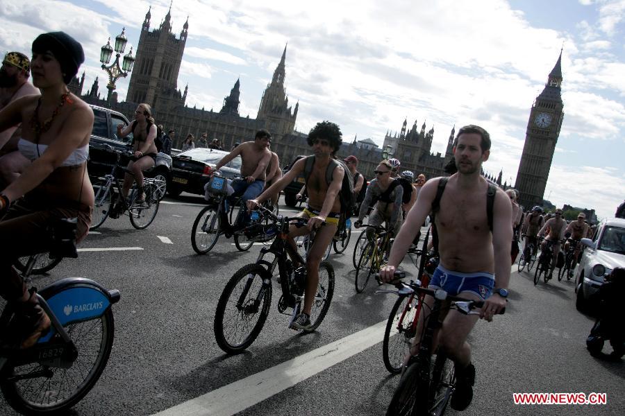 Hundreds of naked or partially naked people ride bicycles on the World Naked Bike Ride Day in London, June 9, 2012. [Xinhua]
