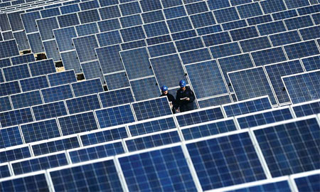 Two workers check photovoltaic panels in a solar power plant in Qinghai province, where the industry has a competitive edge. [Xinhua] 