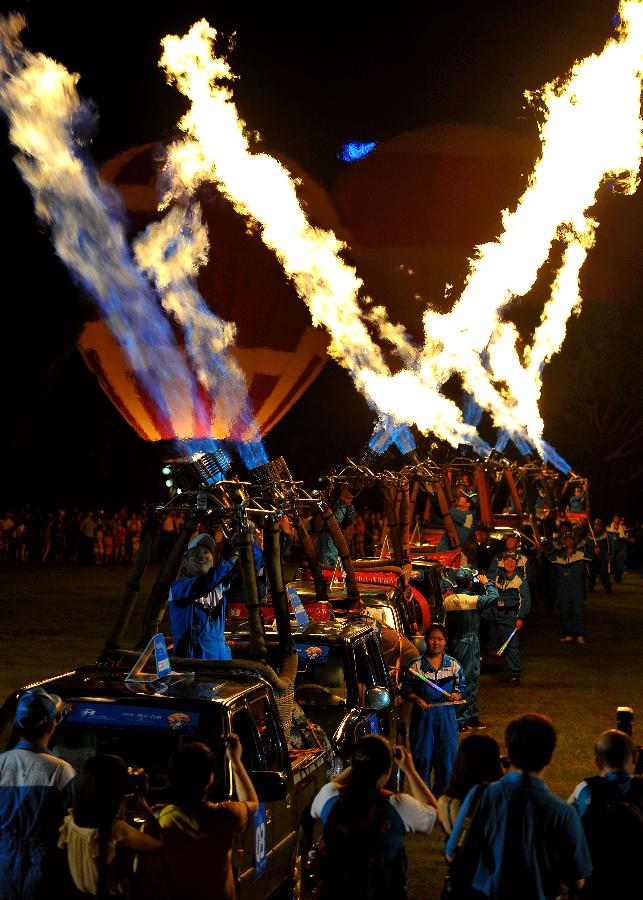 Balloonists perform during the openning ceremony for H1 Hot Air Balloon Challenge in Haikou, capital of south China&apos;s Hainan Province, June 9, 2012. (Xinhua/Guo Cheng) 