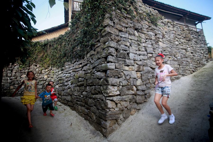 Children play in Donghuang Village of Rong'an County, south China's Guangxi Zhuang Autonomous Region, June 9, 2012. Stone houses, stone walls, stone steps and stone bridges are still well-preserved here after a history of more than 350 years. Residents in this stone village lead a different life now as local economy develops. However, most of them perfer to living in traditional stone houses, which are warm in winter and cool in summer. (Xinhua/Wang Zichuang) 