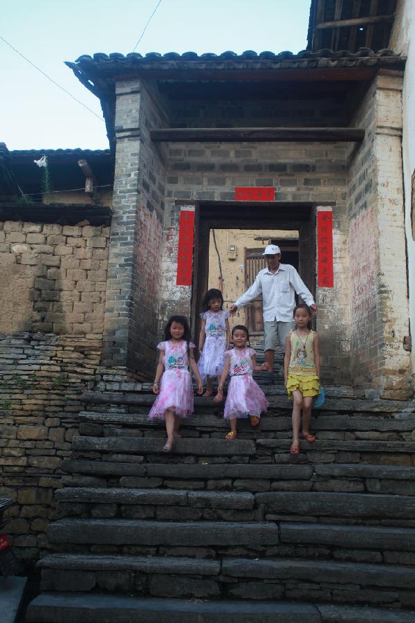 Residents walk downstairs in Donghuang Village of Rong'an County, south China's Guangxi Zhuang Autonomous Region, June 9, 2012. Stone houses, stone walls, stone steps and stone bridges are still well-preserved here after a history of more than 350 years. Residents in this stone village lead a different life now as local economy develops. However, most of them perfer to living in traditional stone houses, which are warm in winter and cool in summer. (Xinhua/Wang Zichuang) 