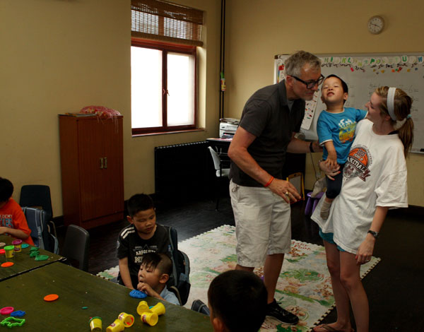 Tim Parker and one of his US college interns play with children at the orphanage.