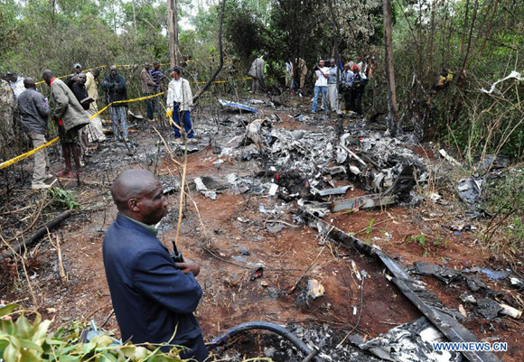 Rescue workers investigate the helicopter crash site in Ngong Forest in the outskirts of Nairobi, Kenya, June 10, 2012. Six Kenyan government officials, including Internal Security minister Professor George Saitoti and his deputy Orwa Ojode, were killed when a police helicopter crashed early Sunday near Nairobi. 