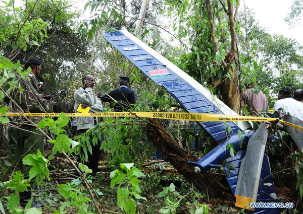Rescue workers investigate the helicopter crash site in Ngong Forest in the outskirts of Nairobi, Kenya, June 10, 2012. Six Kenyan government officials, including Internal Security minister Professor George Saitoti and his deputy Orwa Ojode, were killed when a police helicopter crashed early Sunday near Nairobi.