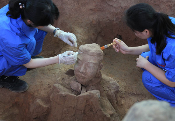  Archeologists excavate a terracotta warrior in Xi'an, Shaanxi province, on Saturday. [ Photo / China Daily ]