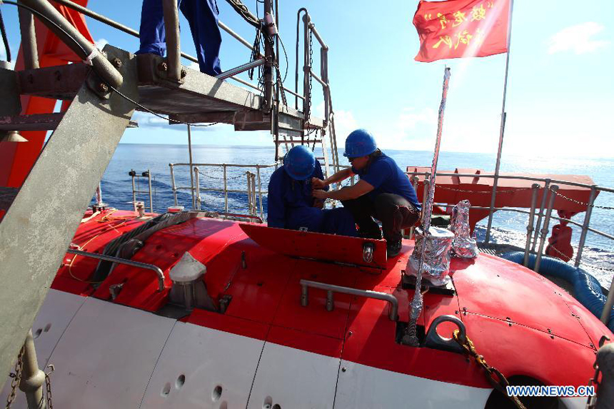 Scientists work on the Jiaolong manned deep-sea submersible aboard China's oceanographic ship Xiangyanghong 09, June 11, 2012. The Jiaolong is scheduled to start its journey to the Mariana Trench with an attempt at the world's first 7,000-meter dive below the surface of the Pacific Ocean. [Xinhua]