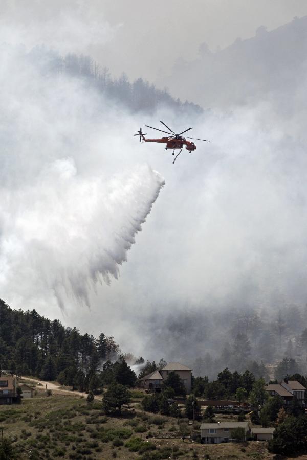 A helicopter drops water on the High Park wildfire burning near homes west of Fort Collins, Colo. , on Monday, June 11, 2012. Massive wildfires in drought-parched Colorado and New Mexico tested the resources of state and federal crews Monday and underscored the need to replenish an aging U.S. aerial firefighting fleet needed to combat a year-round fire season.