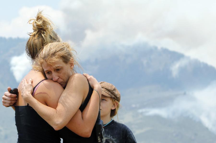 Tracy Greenwood embraces her daughter, Mariah Greenwood, as they watch the High Park wildfire burn near their home west of Fort Collins, Colo. , June 11, 2012.