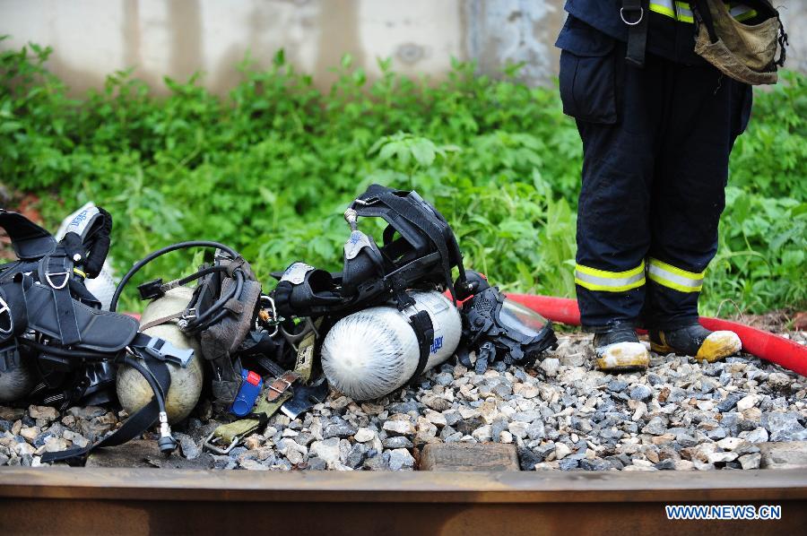 Firemen work at the spot of accident in Wangjiao chemical plant in Shenyang, capital of northeast China's Liaoning Province, June 12, 2012. A depot of the factory exploded at 4:30 p.m. in the Yuhong district, shattering windows at a distance of 200 meters and resulting in a massive cloud of smoke, witnesses said. 