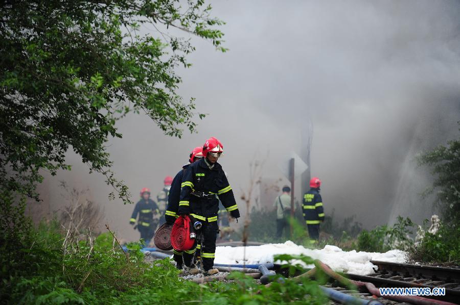 Firemen work at the spot of accident in Wangjiao chemical plant in Shenyang, capital of northeast China's Liaoning Province, June 12, 2012. A depot of the factory exploded at 4:30 p.m. in the Yuhong district, shattering windows at a distance of 200 meters and resulting in a massive cloud of smoke, witnesses said. 