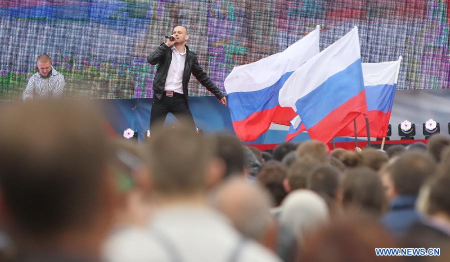 People watch performance at the Place Square in front of the Winter Palace while taking part in the celebration of the &apos;Day of Russia&apos; in St. Petersburg, Russia, June 12, 2012. Russia celebrated on Tuesday its national holiday, the &apos;Day of Russia&apos;, with mass culture events held throughout the country.