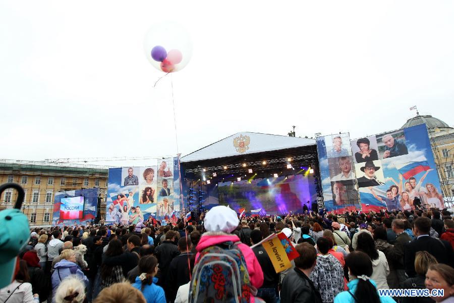 People gather at the Place Square in front of the Winter Palace to take part in the celebration of the 'Day of Russia' in St. Petersburg, Russia, June 12, 2012. Russia celebrated on Tuesday its national holiday, the 'Day of Russia', with mass culture events held throughout the country. 