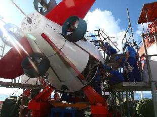 Scientists work on the Jiaolong manned deep-sea submersible aboard China's oceanographic ship Xiangyanghong 09, June 11, 2012. The Jiaolong is scheduled to start its journey to the Mariana Trench with an attempt at the world's first 7,000-meter dive below the surface of the Pacific Ocean. [Photo / Xinhua]