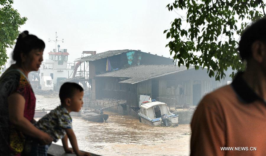 Citizens watch the flood peak of the Changsha reach of Xiangjiang River in Changsha, central China's Hunan Province, June 13, 2012. Xiangjiang River's flood peak passed its Changsha reach smoothly on Wednesday. (Xinhua/Long Hongtao) 