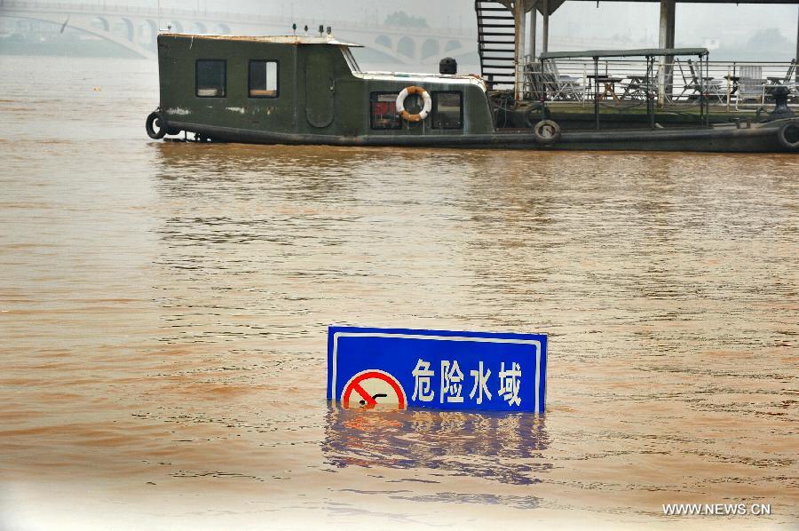 Photo taken on June 13, 2012 shows a sign submerged in the flood peak of the Changsha reach of Xiangjiang River in Changsha, central China's Hunan Province. Xiangjiang River's flood peak passed its Changsha reach smoothly on Wednesday. (Xinhua/Long Hongtao)