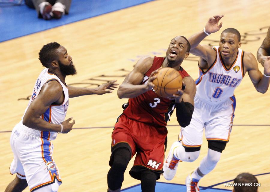 Miami Heat's Dwyane Wade (C) goes up to the basket during Game 1 against Oklahoma City Thunder at the NBA basketball finals in Oklahoma City, the United States, June 12, 2012. Thunder won 105-94. (Xinhua/Song Qiong) 