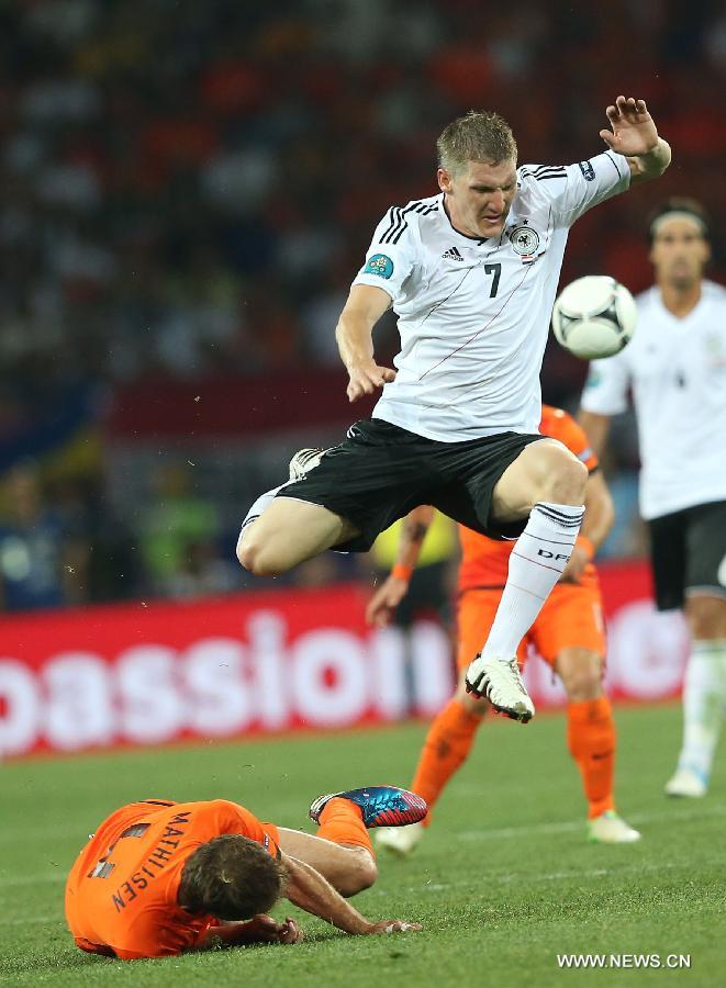 Bastian Schweinsteiger (Up) of Germany vies with Joris Mathijsen of Netherlands during their Group B 2nd round match at the Euro 2012 football championships in Kharkiv, Ukraine, June 13, 2012. Germany won 2-1. (Xinhua/Meng Yongmin) 