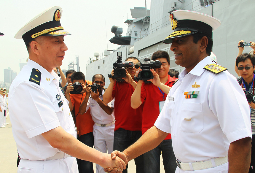 Rear Admiral P. Ajit Kumar of India (R) and Chinese Naval Commander Shen Hao (L) shake hands at a welcoming ceremony for the visiting Indian naval fleet at a port along the Huangpu River in Shanghai, June 13, 2012. [Xinhua photo]