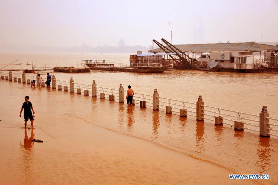 A man wades at the embankment in Changsha, capital of central China&apos;s Hunan Province, June 14, 2012. The flood peak of Xiangjiang River passed through Changsha on Wednesday. (Xinhua/Zhao Zhongzhi) 