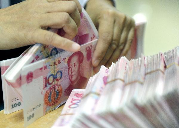 Photo taken on Nov. 18, 2010 shows a teller counting the Renminbi at a bank in Qionghai City, south China's Hainan Province.