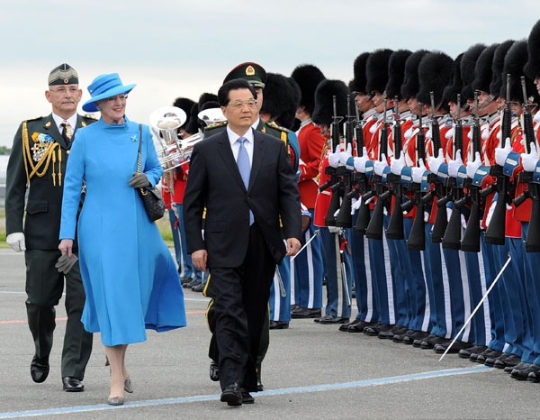 Chinese President Hu Jintao (R, front) attends a welcoming ceremony held by Denmark's Queen Margrethe II (L, front) upon his arrival in Copenhagen, Denmark, June 14, 2012. Hu Jintao arrived here on Thursday for a state visit to Denmark. [Li Tao/Xinhua]