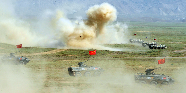 Armored cars and Chinese soldiers participate in the Peace Mission 2012 anti-terror drill held by Shanghai Cooperation Organization countries in Tajikistan on Thursday. The drill involved about 2,000 military personnel from China, Kazakhstan, Kyrgyzstan, Russia and Tajikistan. [Li Jing/For China Daily]
