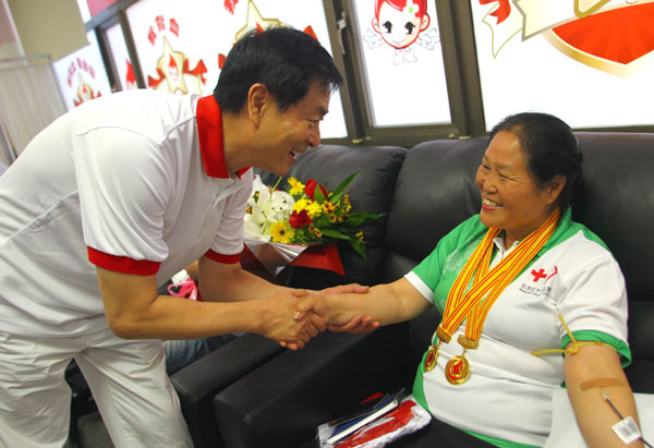 Zhang Guihua (right), a retired worker, donates blood at the Beijing Red Cross Blood Center on Thursday, watched by actor Pu Cunxin, who is a voluntary blood donation promotion ambassador for the Ministry of Health. It was Zhang's 130th blood donation, and she was donating as part of the annual World Blood Donor Day. [ Photo / China Daily ]