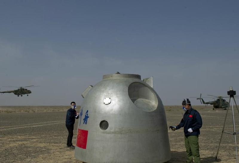 Scientific workers check a simulation spacecraft capsule during an exercise, June 13, 2012. [Photo/Asianewsphoto]