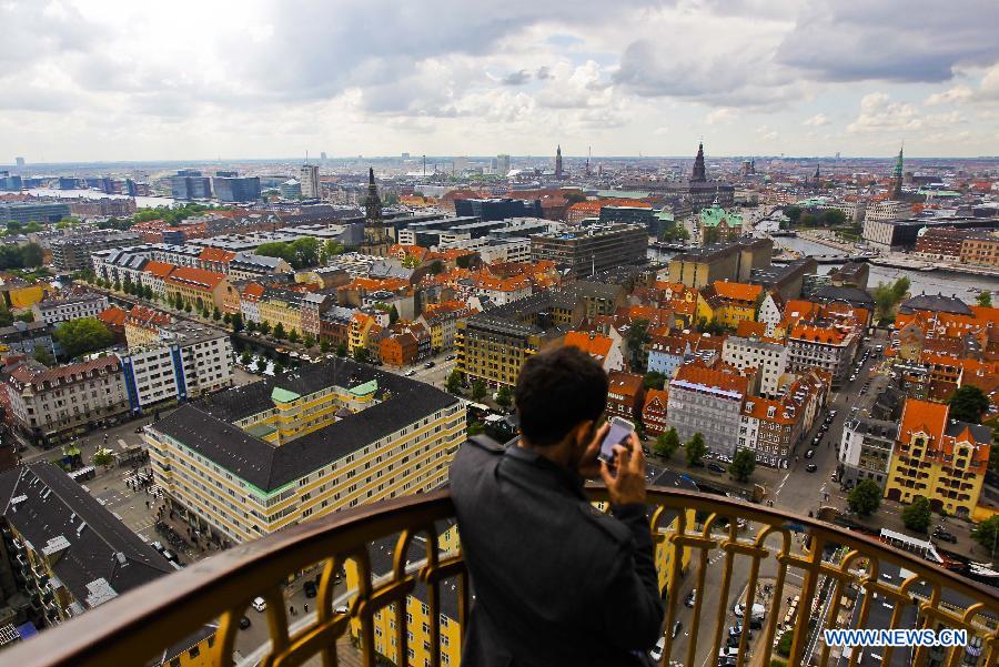 A tourist stands on the stairs of a church in Copenhagen, capital of Denmark, June 11, 2012. (Xinhua/Zhou Lei) 