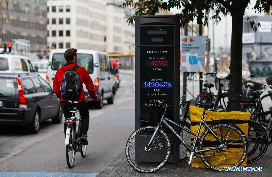 A man rides past a bicycle traffic mornitor in Copenhagen, capital of Denmark, June 13, 2012. (Xinhua/Zhou Lei) 