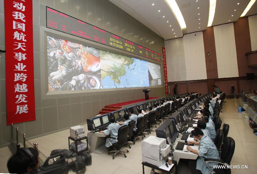 Staff members work during the launch of China's manned Shenzhou-9 spacecraft at the Beijing Aerospace Flight Control Center, in Beijing, capital of China, June 16, 2012. Shenzhou-9, atop an upgraded Long March-2F carrier rocket, blast off from the Jiuquan Satellite Launch Center in northwestern China at 6:37 p.m. Saturday and accurately entered its orbit. (Xinhua/Wang Shen) 