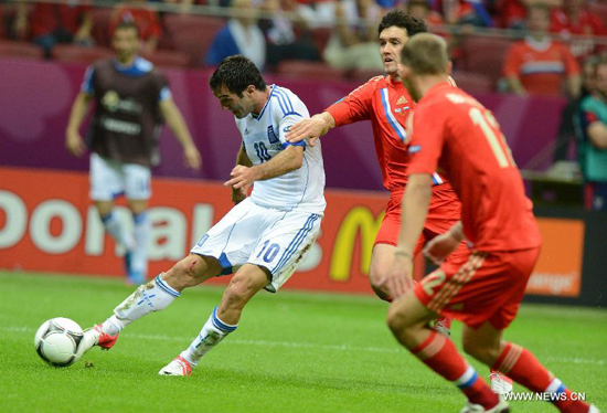Giorgos Karagounis (L) of Greece scores during the Group A 3rd round match against Russia at the Euro 2012 football championships in Warsaw, Poland, June 16, 2012.