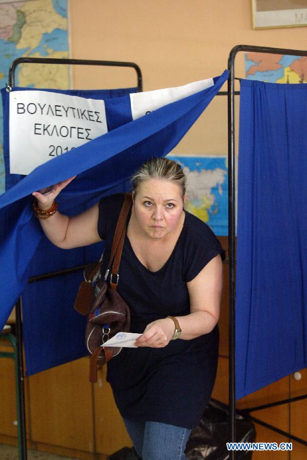 A woman prepares to cast her vote in Athens, Greece, June 17, 2012. Greeks went to the polls on Sunday in the second round of parliamentary elections in six weeks seen as a referendum on bailout deals and the debt-laden country's fate in the eurozone.