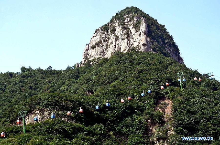 Cable cars are seen at the scenic area of Huilong Village in the Taihang Moutains in Huixian County, central China&apos;s Henan Province, June 14, 2012