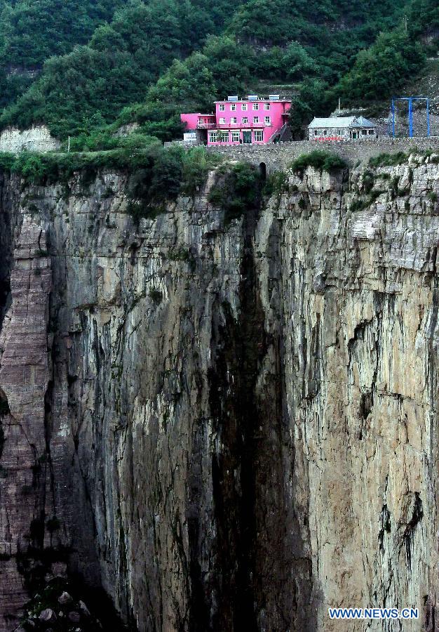 A home inn is seen beside a cliff at Huilong Village in the Taihang Moutains in Huixian County, central China's Henan Province, June 14, 2012.