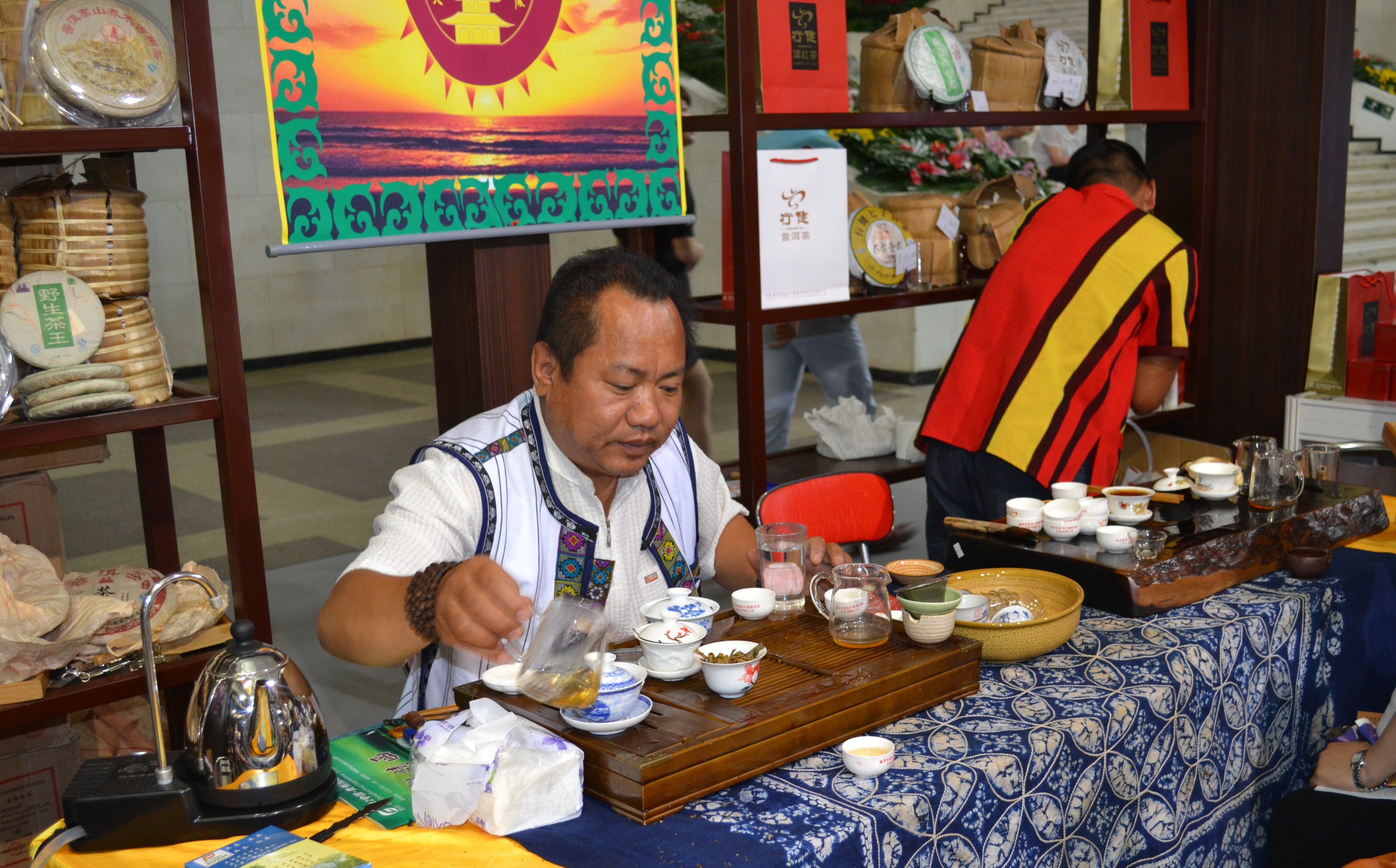 Li Qiwei from the Jinggu Tiancheng Ancient Tree Tea Factory from Jinggu, Pu’er City, Yunnan pours Pu’er tea for guests at the Beijing International Tea Expo 2012. [Corey Cooper/china.org.cn] 