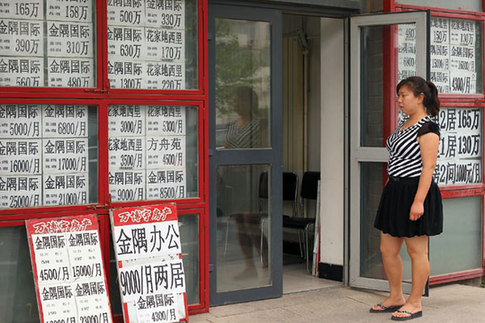 A real estate agent checks advertisements for secondhand housing in Beijing. Since May, there has been a rush in buying secondhand houses in the city, and this month, estate agents have reported insufficient supply. [China Daily] 