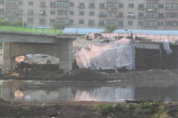 A bridge under construction collapsed in Fushun city, Northeast China's Liaoning province, June 18, 2012. The 416.4-meter bridge over a river cost 29 million yuan ($4.6 million) in local government investment and was expected to be completed by July 1, 2012. The cause of the collapse is still unknown and no injury was reported. [Photo/CFP]