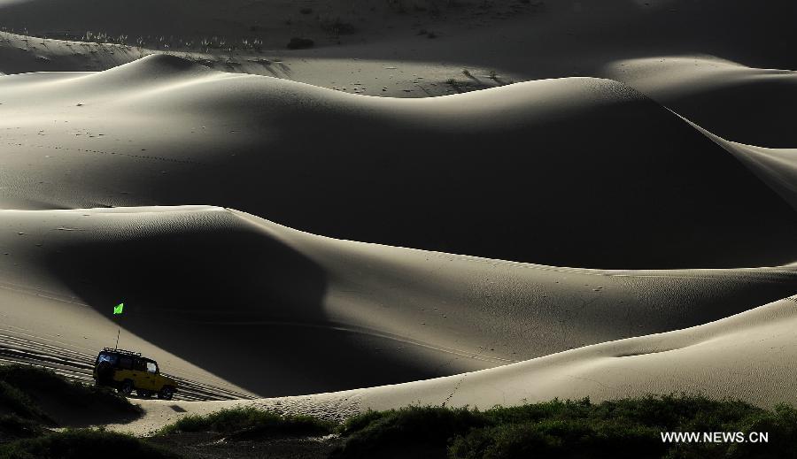 A motorcar runs on the Badain Jaran Desert in Alashan of north China's Inner Mongolia Autonomous Region, June 19, 2012. The Badian Jaran Desert is 47,000 square km and sparsely populated. It is famous for having the tallest stationary sand dunes in the world. Some dunes reach a height of 500 meters. But it also features spring-fed lakes that lie between the dunes. (Xinhua/Wang Peng) 