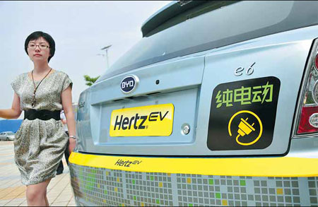 A woman with her rented electric car from Hertz Car Rental in Shenzhen. Beijing-based China Auto Rental now is the country's largest vehicle-leasing agency, measured by fleet size. The company has postponed its public listing in the United States. Yuan shuiling / for China Daily