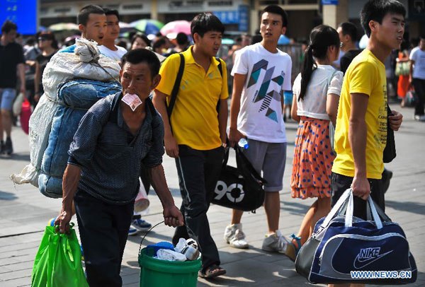 Passengers walks out of the Xi'an Railway Station in Xi'an, northwest China's Shaanxi Province, June 22, 2012. A total of 770,000 passenger trips are expected for Xi'an Railway Bureau during the three-day holdiay of Dragon Boat Festival this year, which lasts from Friday to Sunday. [Xinhua]