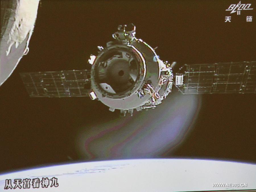 Photo taken on June 24, 2012 shows the screen at the Beijing Aerospace Control Center showing Shenzhou-9 manned spacecraft parting from the orbiting Tiangong-1 space lab to prepare for the country's first manual space docking. The spacecraft and the space lab were joined together by an automated docking on June 18. (Xinhua/Zha Chunming) 
