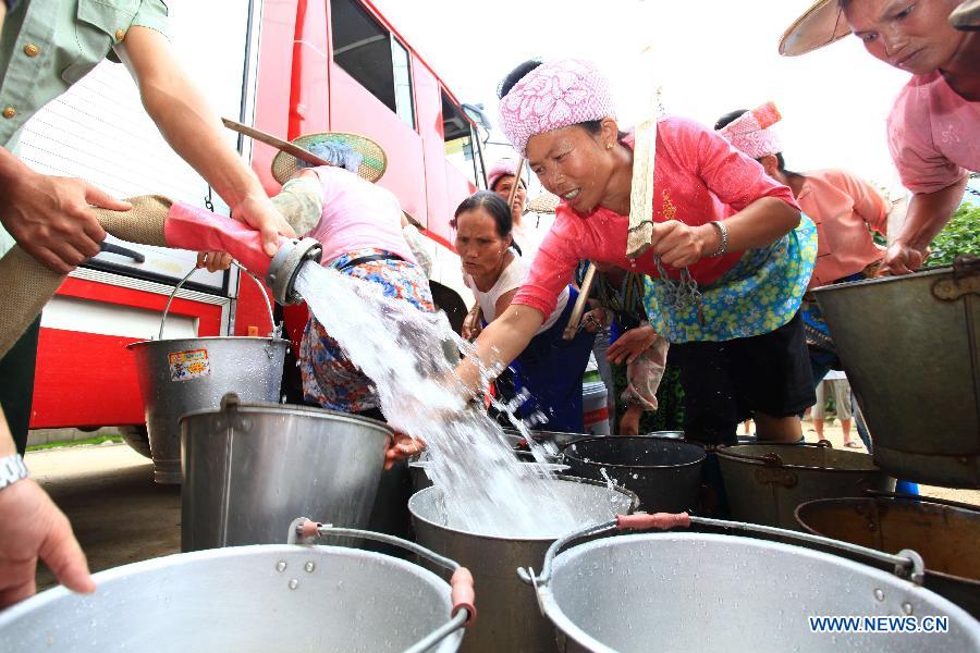 Villagers clear silt in Fanmeng Village of Yingjiang County, southwest China's Yunnan Province, June 24, 2012